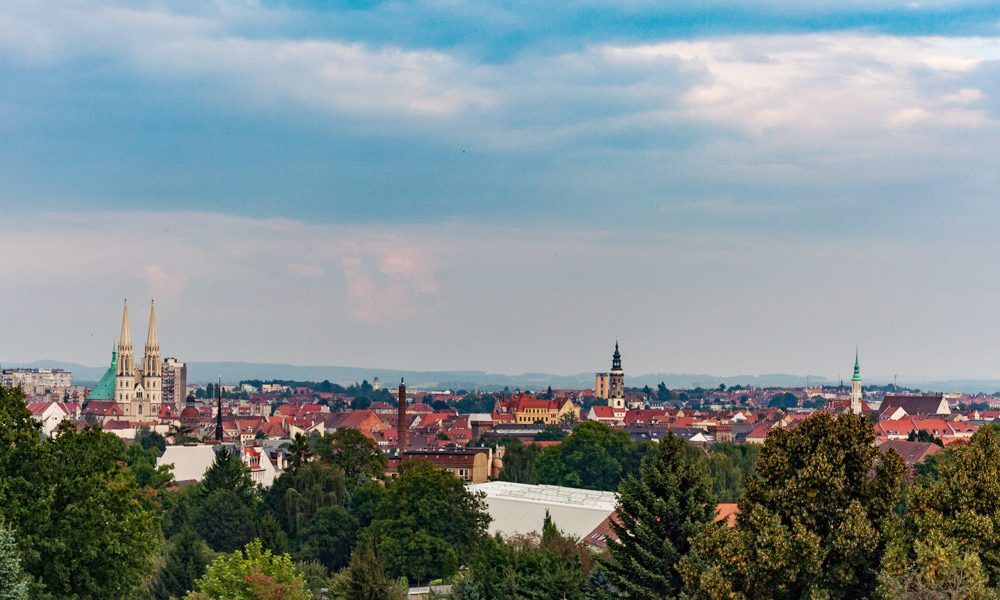 Blick auf die Peterskriche, den Rathausturm und die Dreifaltigkeitskirche, mit dem Riesengebierge am Horizont